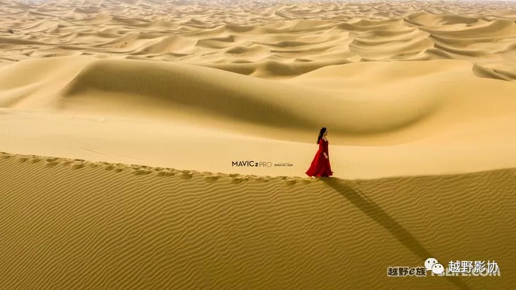 Aerial female driver driving a Wrangler across the Kubuqi Desert