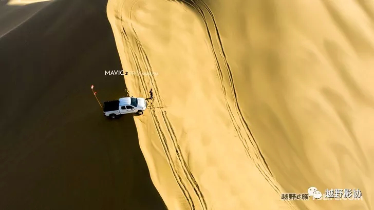 Aerial female driver driving a Wrangler across the Kubuqi Desert